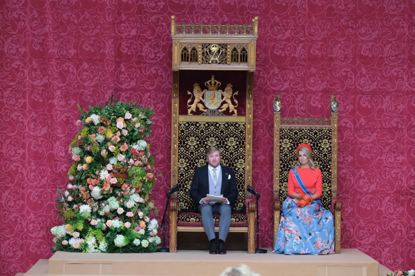 Koning Willem Alexander en koningin Maxima zitten op de troon