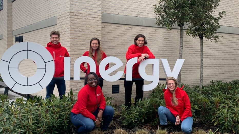 Een groepsfoto van Young Professionals in rode jasjes, collega's van Inergy voor het kantoor in Woerden van Inergy