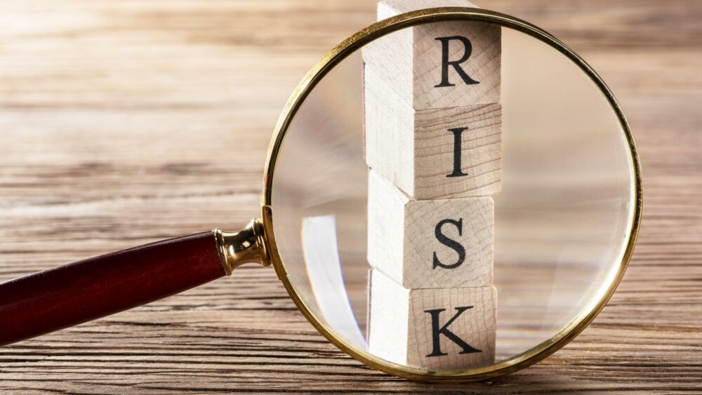 Magnifying glass with the word Risk or Risk