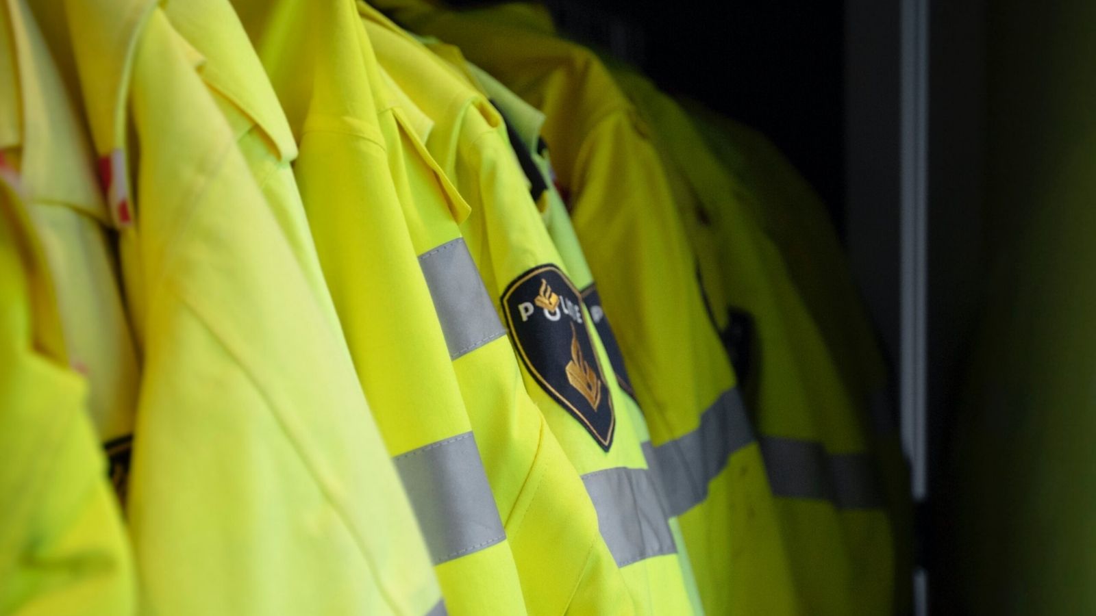 verschillende gele politie jassen hangen aan de kapstok