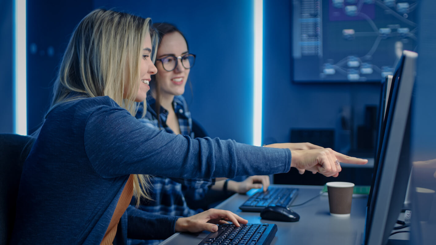 twee vrouwen zitten te werken achter computers